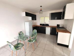 a kitchen with a glass table and four chairs at Cozy spa sun set in Trois Bassins