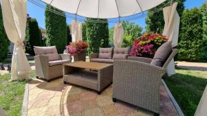 a patio with wicker chairs and a table with flowers at Vila Adria in Hrabušice +71 photos