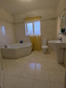 a bathroom with a tub and a toilet and a sink at Cloonacauneen House in Balnacart +21 photos