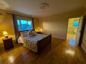 a bedroom with a bed with a teddy bear on it at Cloonacauneen House in Balnacart