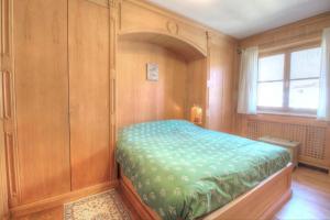 a bedroom with a bed in a room with a window at Botton d'oro in Borca di Cadore