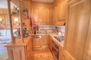 a kitchen with wooden cabinets and a stove top oven at Botton d'oro in Borca di Cadore