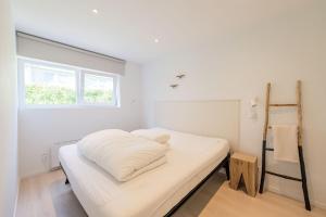 a white bedroom with a bed and a window at Lovely Duplex Axime with beautiful hill views - Malmedy in Malmedy