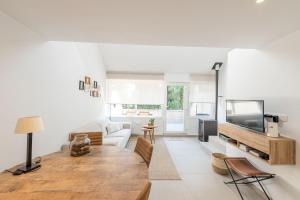 a living room with a couch and a tv at Lovely Duplex Axime with beautiful hill views - Malmedy in Malmedy