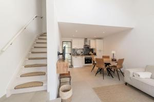 a white living room with a staircase and a kitchen at Lovely Duplex Axime with beautiful hill views - Malmedy in Malmedy +20 photos