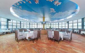 a dining room with tables and chairs and a large ceiling at Shenzhen Xingwei Yifeng Hotel in Shenzhen