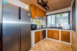 a kitchen with a stainless steel refrigerator and wooden cabinets at Let go see the Dolphin Samroiyot in Baanphakrimlay 