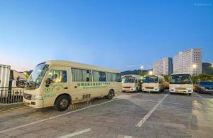 a group of buses parked in a parking lot at Shenzhen Xingwei Yifeng Hotel in Shenzhen