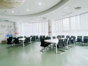 a conference room with tables and chairs and windows at Shenzhen Xingwei Yifeng Hotel in Shenzhen
