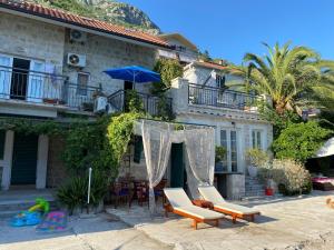 a house with a patio with chairs and an umbrella at Boka Bay Beach House in Dražin Vrt