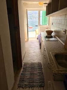 a kitchen with a sink and a view of the ocean at Boka Bay Beach House in Dražin Vrt
