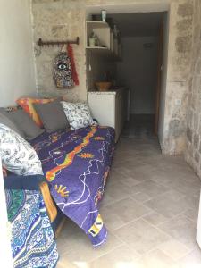 a room with a bed with a purple comforter at Boka Bay Beach House in Dražin Vrt +15 photos