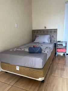 a bed with a blue bag on it in a bedroom at Pousada Taylor in Foz do Iguaçu