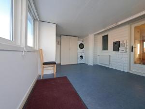 an empty room with a chair and a washing machine at Michelle's Blue House in Ilulissat