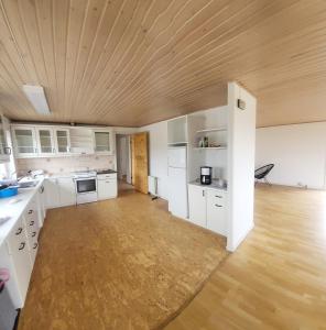 a kitchen with white cabinets and a wooden ceiling at Michelle's Blue House in Ilulissat