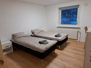 two twin beds in a room with a window at Michelle's Blue House in Ilulissat
