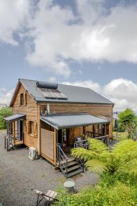 a log cabin with a porch and a roof at Barbadine974, Chalet cosy, 6 personnes, Plaine des Cafres in La Plaine des Cafres