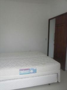 a white bed with a sign on top of it at Apartamento da Vanda in Ubatuba