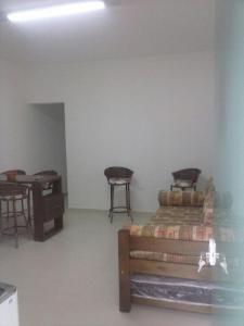 a room with two chairs and a bed and a table at Apartamento da Vanda in Ubatuba