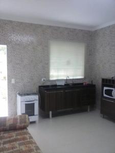 a living room with a window and a microwave at Apartamento da Vanda in Ubatuba