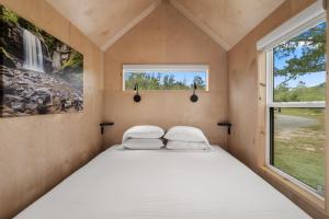 a bed in a small room with a window at Asheville River Cabins, WorldHotels Backdrop in Arden
