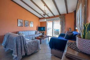 a living room with a blue couch and a tv at Villa ELENA in Alexandroupoli