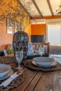 a wooden table with plates and wine glasses on it at Villa ELENA in Alexandroupoli +44 photos