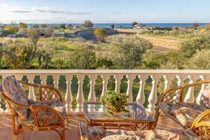 a patio with chairs and a table on a balcony at Villa ELENA in Alexandroupoli