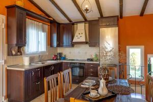 a kitchen with wooden cabinets and a table with a dining room at Villa ELENA in Alexandroupoli