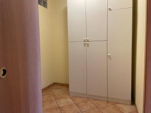 a closet with white cabinets and a tile floor at Fior Di Sambuco in Broni