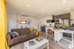 a living room with a couch and a kitchen at Gite de l'artiste in Fay-les-Étangs