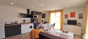 a kitchen with a living room with a couch at Gite de l'artiste in Fay-les-Étangs +3 photos