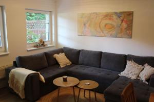 a living room with a blue couch and two tables at Ferienwohnung Annette Mieth in Weitenhagen