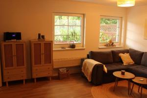 a living room with a couch and two windows at Ferienwohnung Annette Mieth in Weitenhagen