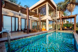 an exterior view of a house with a swimming pool at Let go see the Dolphin Samroiyot in Baanphakrimlay 