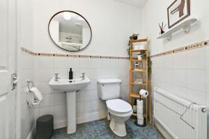a bathroom with a toilet and a sink and a mirror at Wolfe Tone Apartment in Sligo +31 photos