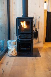 a stove with a fire in a room with at Cabin stay with optional Donkey Picnic Experience in Hallau
