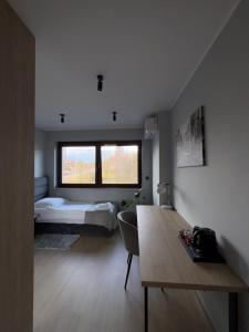 a bedroom with a bed and a table in a room at Arcadia Home in Będzin