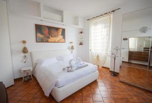 a bedroom with a white bed and a mirror at Casa Emi in Lezzeno