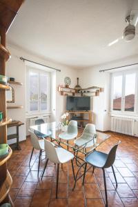 a dining room with a glass table and chairs at Casa Emi in Lezzeno