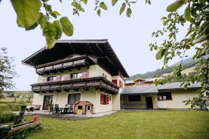 a large house with a green yard in front of it at Ferienhaus Nationalpark in Neukirchen am Großvenediger
