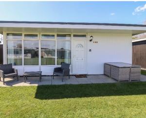 a white house with two chairs and a table at 106 Cherry park in Chapel Saint Leonards
