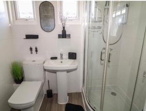 a white bathroom with a sink and a shower at 106 Cherry park in Chapel Saint Leonards +7 photos