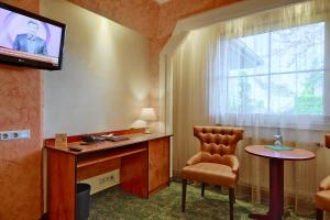ein Zimmer mit Fernseher, Stuhl und Fenster in der Unterkunft Hotel Aragon in Ahrensfelde
