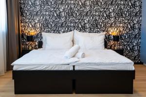 a bedroom with a bed with a black and white wall at Azure Apartman Miskolc in Miskolc