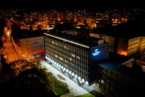 a building with a sign on top of it at night at Azure Apartman Miskolc in Miskolc