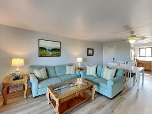 a living room with blue couches and a table at Lighthouse Point 11C in Tybee Island