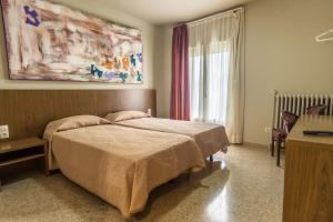 a bedroom with a bed and a large window at Hostal Sant Miquel in Balaguer