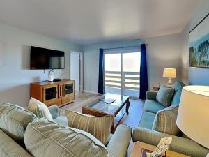 a living room with a couch and a tv at Lighthouse Point 11C in Tybee Island