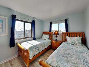 a bedroom with two beds and a window at Lighthouse Point 11C in Tybee Island +58 photos